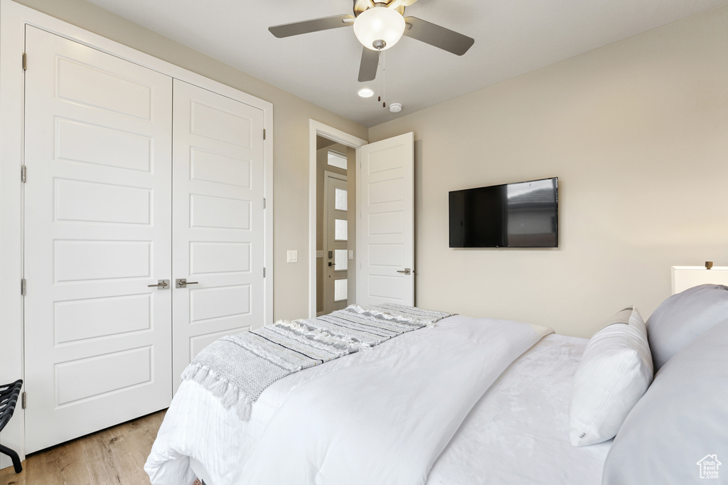 Bedroom with light hardwood / wood-style floors, a closet, and ceiling fan