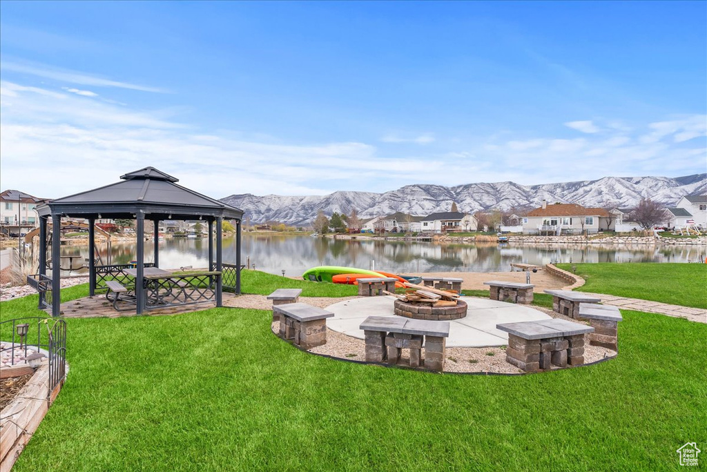 View of yard featuring a gazebo, a water and mountain view, an outdoor fire pit, and a patio area