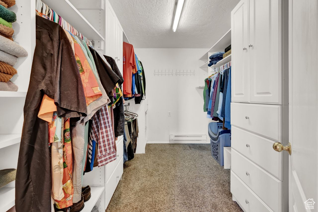 Spacious closet with dark carpet and baseboard heating