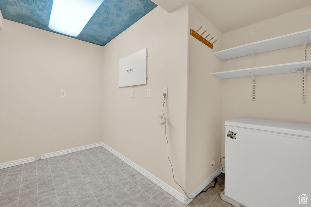 Clothes washing area with light tile floors