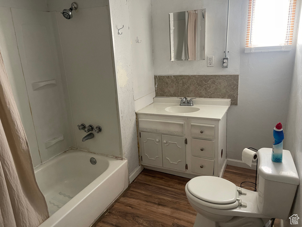 Full bathroom featuring vanity,  shower combination, wood-type flooring, and toilet