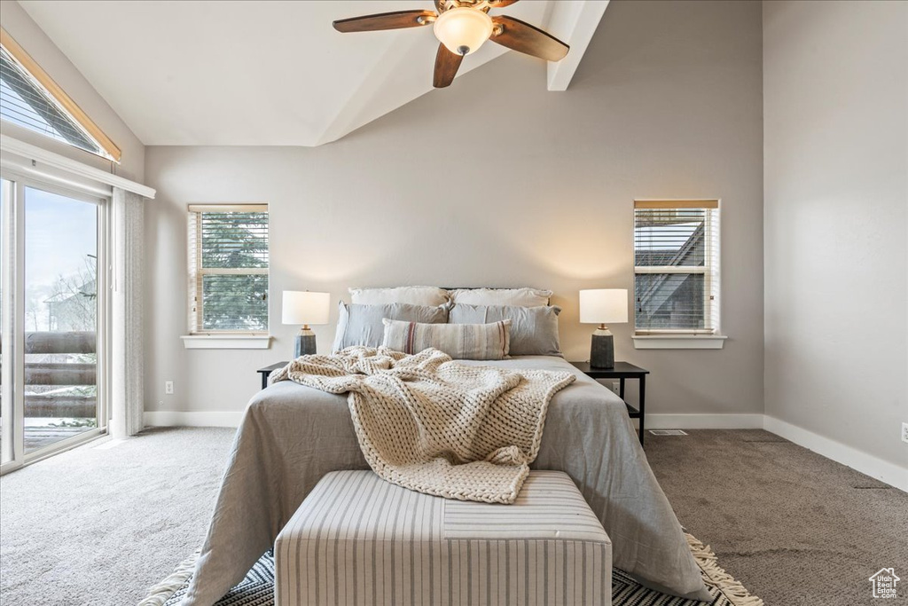 Bedroom with lofted ceiling, dark carpet, ceiling fan, and multiple windows