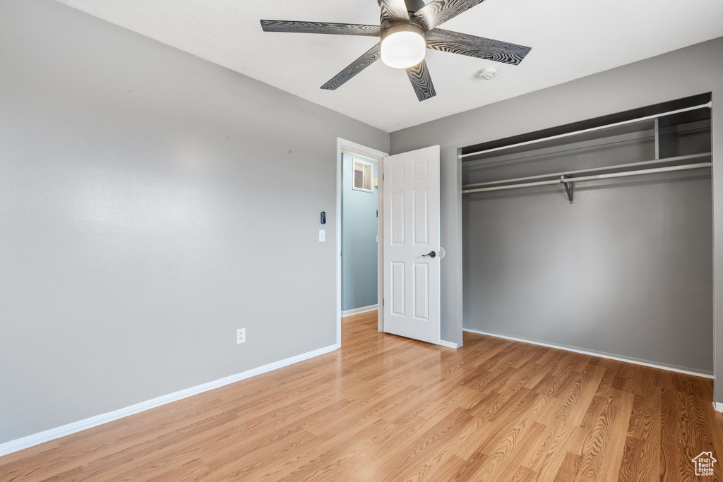 Unfurnished bedroom with a closet, light hardwood / wood-style floors, and ceiling fan