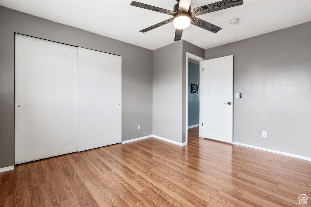 Unfurnished bedroom featuring a closet, ceiling fan, and light wood-type flooring