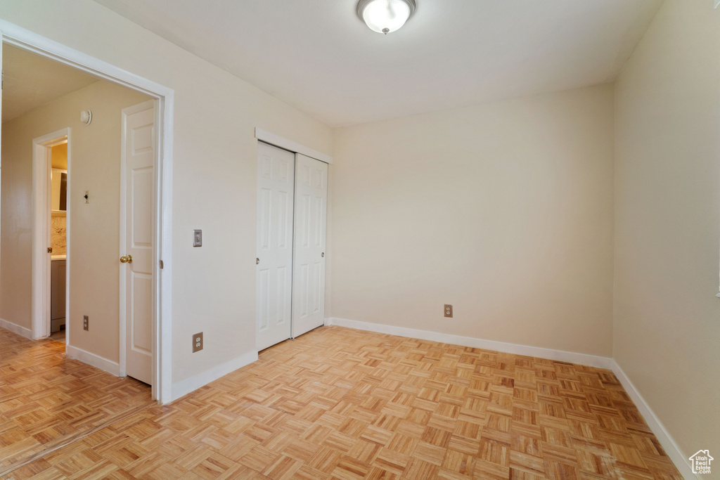 Unfurnished bedroom featuring light parquet flooring