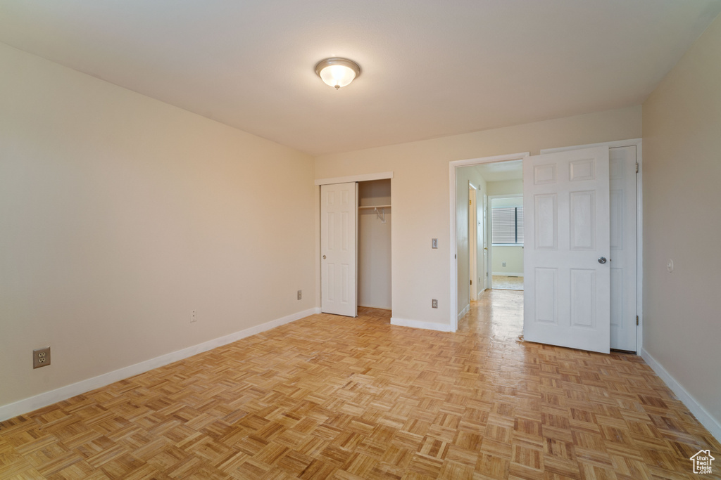 Unfurnished bedroom featuring light parquet floors