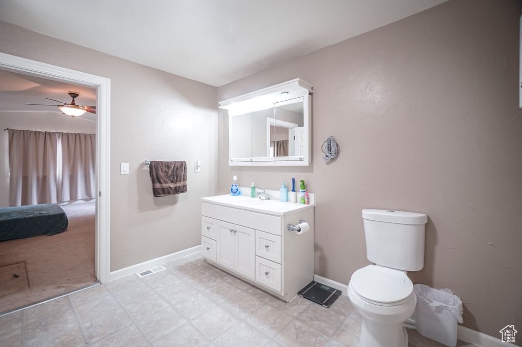 Bathroom featuring tile floors, toilet, vanity, and ceiling fan