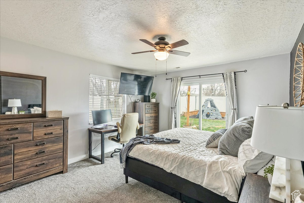 Bedroom featuring light carpet, a textured ceiling, access to exterior, and ceiling fan