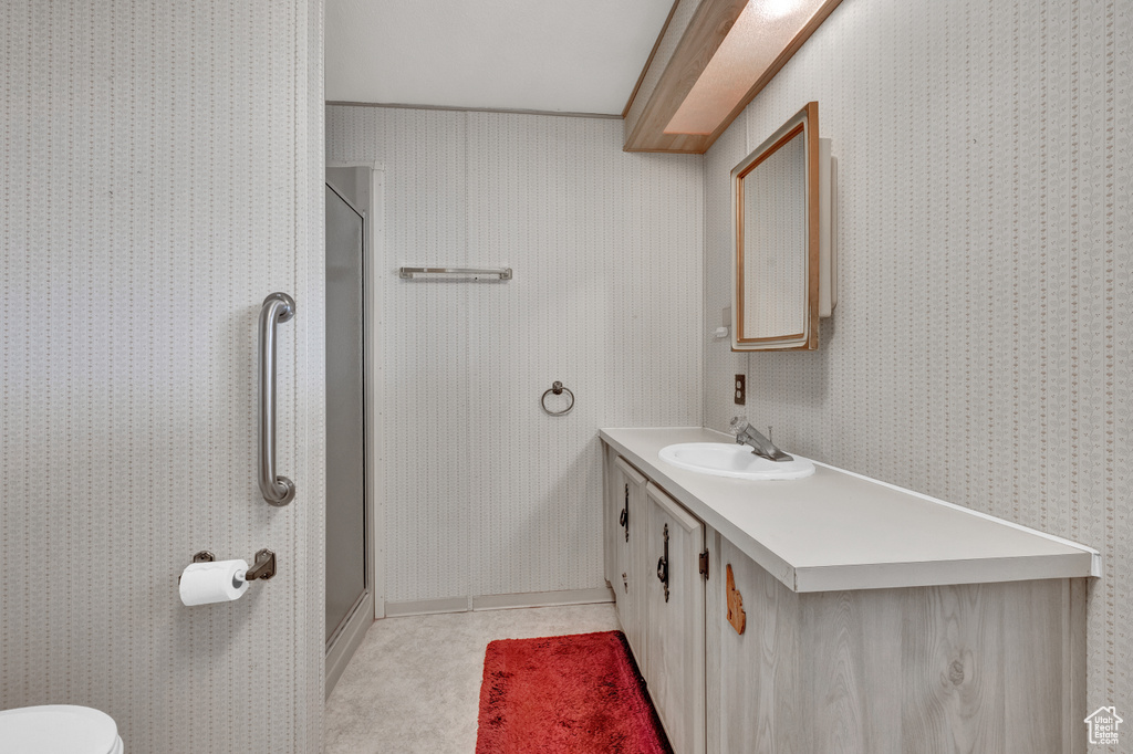 Bathroom featuring vanity, tile floors, toilet, and walk in shower