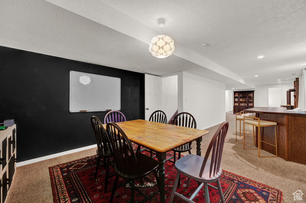 Dining room featuring a textured ceiling and carpet floors