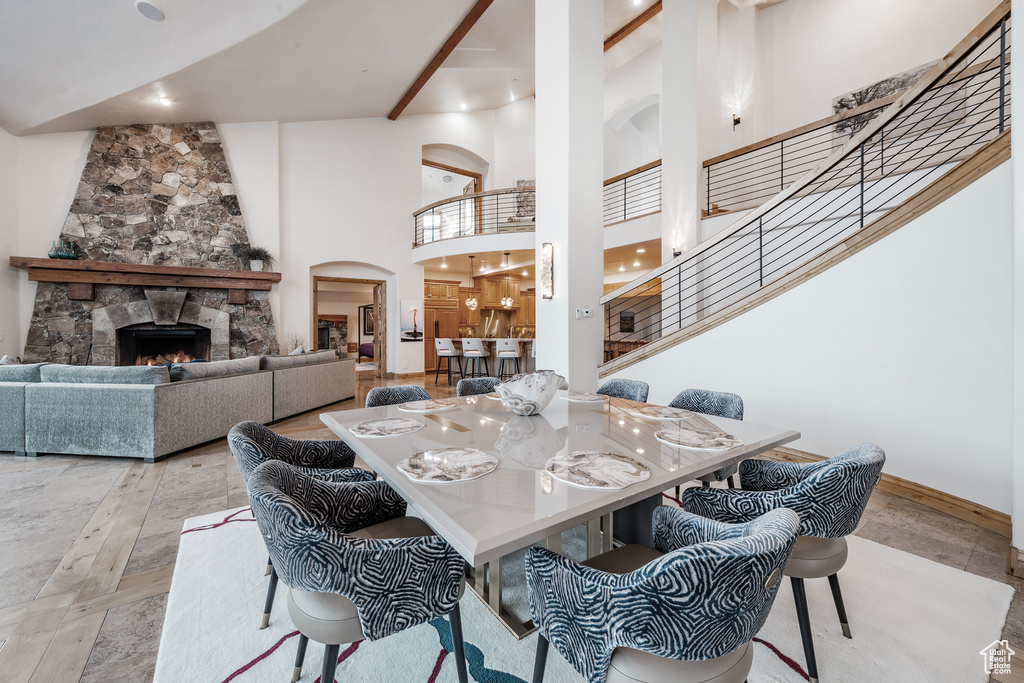 Dining space featuring a stone fireplace and a towering ceiling