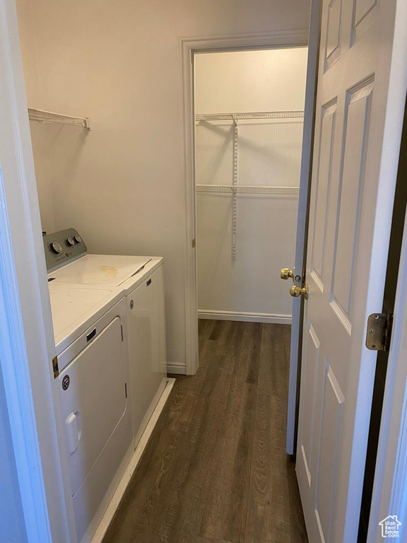 Laundry area with dark hardwood / wood-style floors and washing machine and clothes dryer