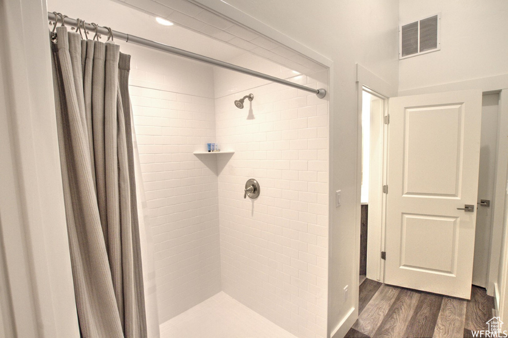 Bathroom featuring hardwood / wood-style floors and a shower with shower curtain