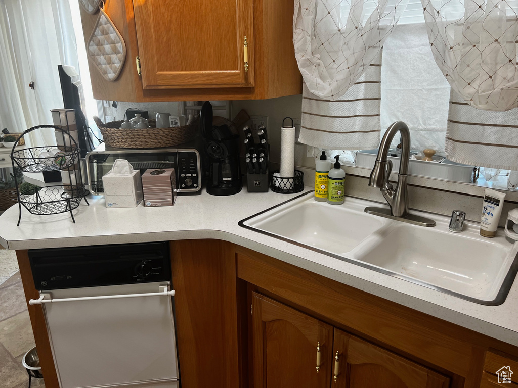 Kitchen featuring dishwashing machine and sink
