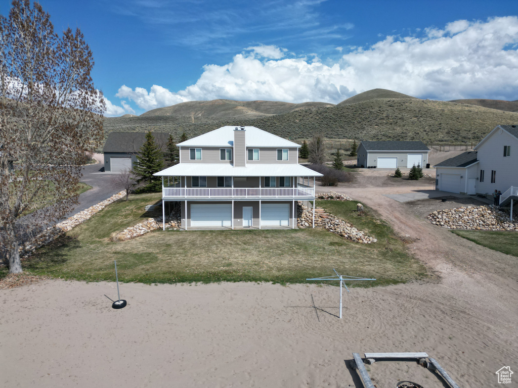 View of front facade with a mountain view, a garage, and a front lawn
