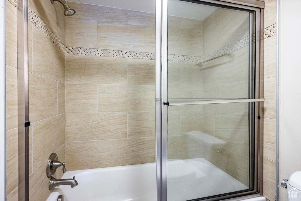 Bathroom featuring bath / shower combo with glass door