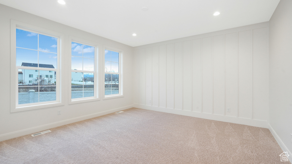Carpeted empty room featuring plenty of natural light