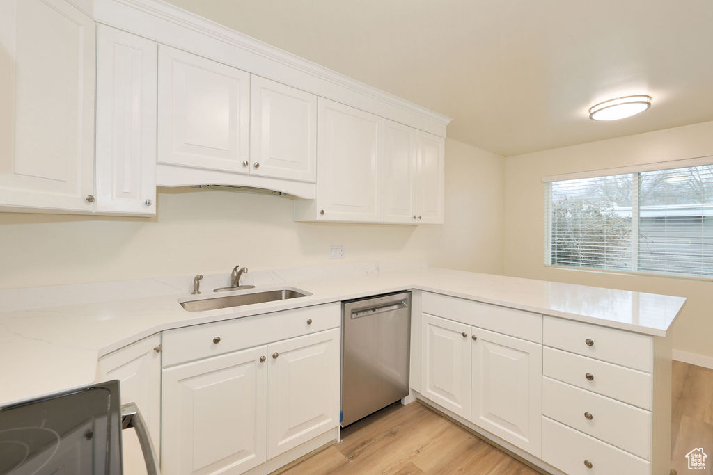 Kitchen with kitchen peninsula, light hardwood / wood-style flooring, white cabinets, dishwasher, and sink