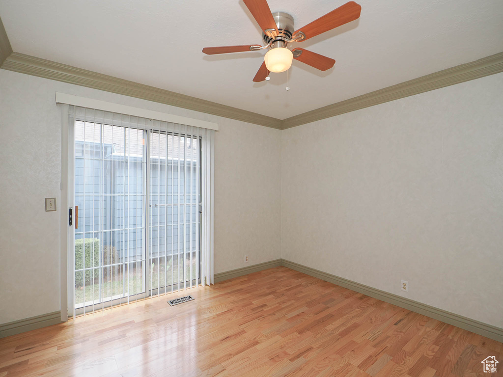 Unfurnished room with plenty of natural light, ornamental molding, ceiling fan, and light hardwood / wood-style flooring