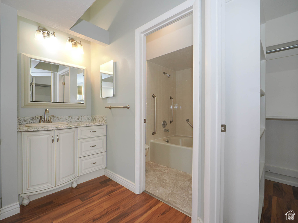 Full bathroom featuring vanity, wood-type flooring, shower / washtub combination, and toilet