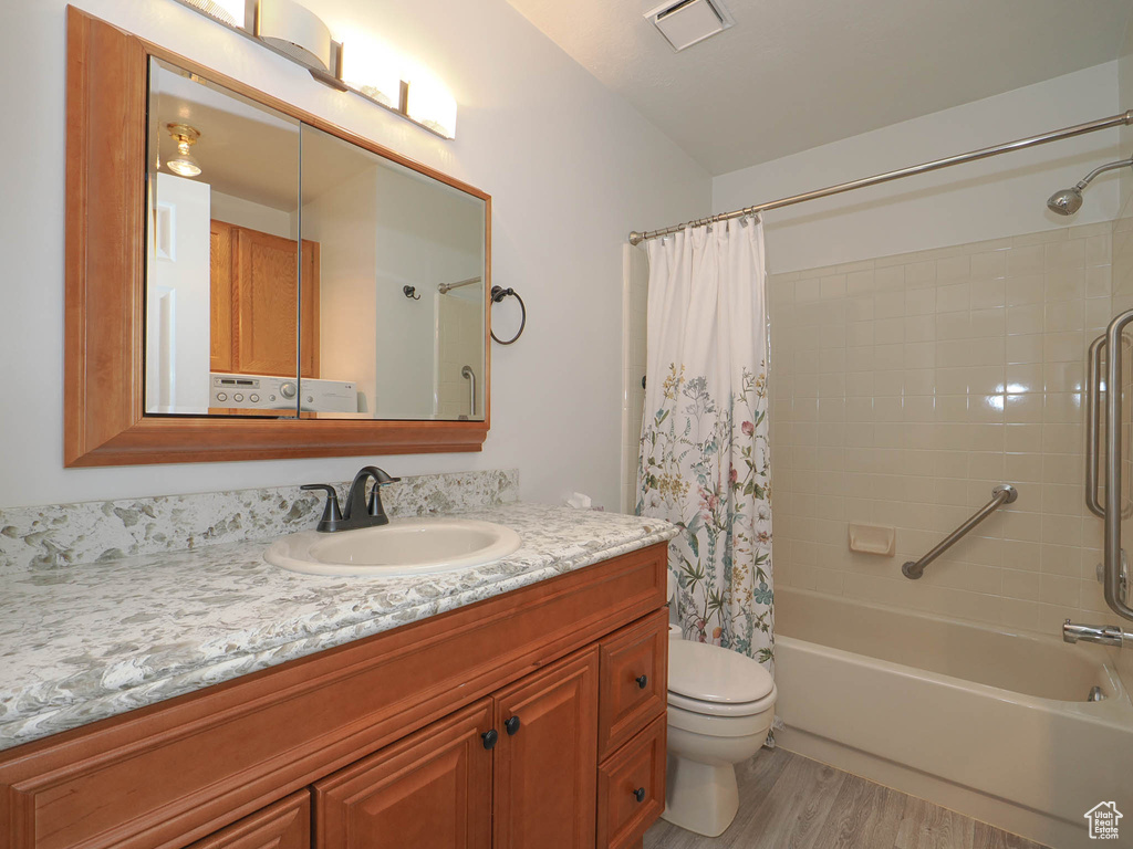 Full bathroom with shower / bath combination with curtain, toilet, vanity, and wood-type flooring