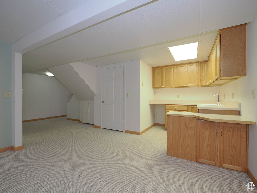 Kitchen featuring light brown cabinets, light colored carpet, and sink