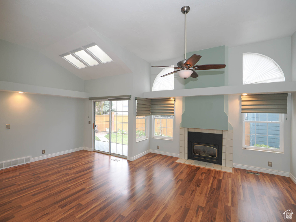 Unfurnished living room with ceiling fan, high vaulted ceiling, and dark hardwood / wood-style flooring