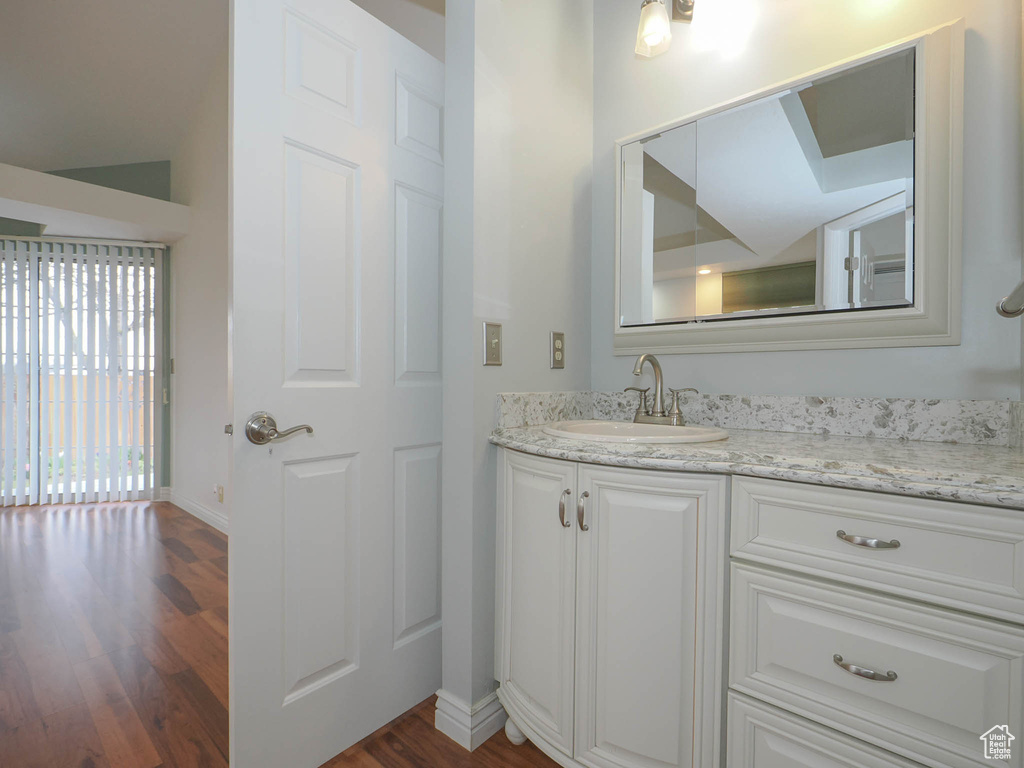 Bathroom featuring vanity with extensive cabinet space and wood-type flooring