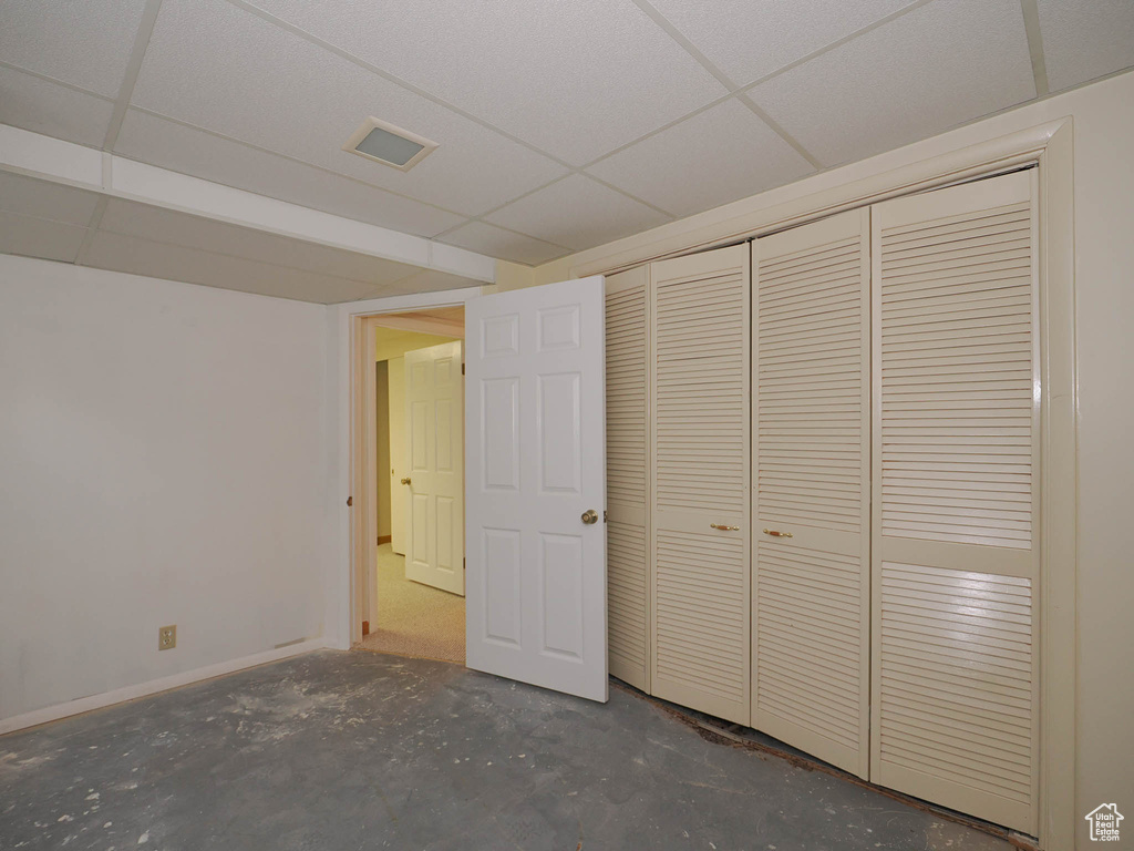 Unfurnished bedroom featuring a paneled ceiling and a closet