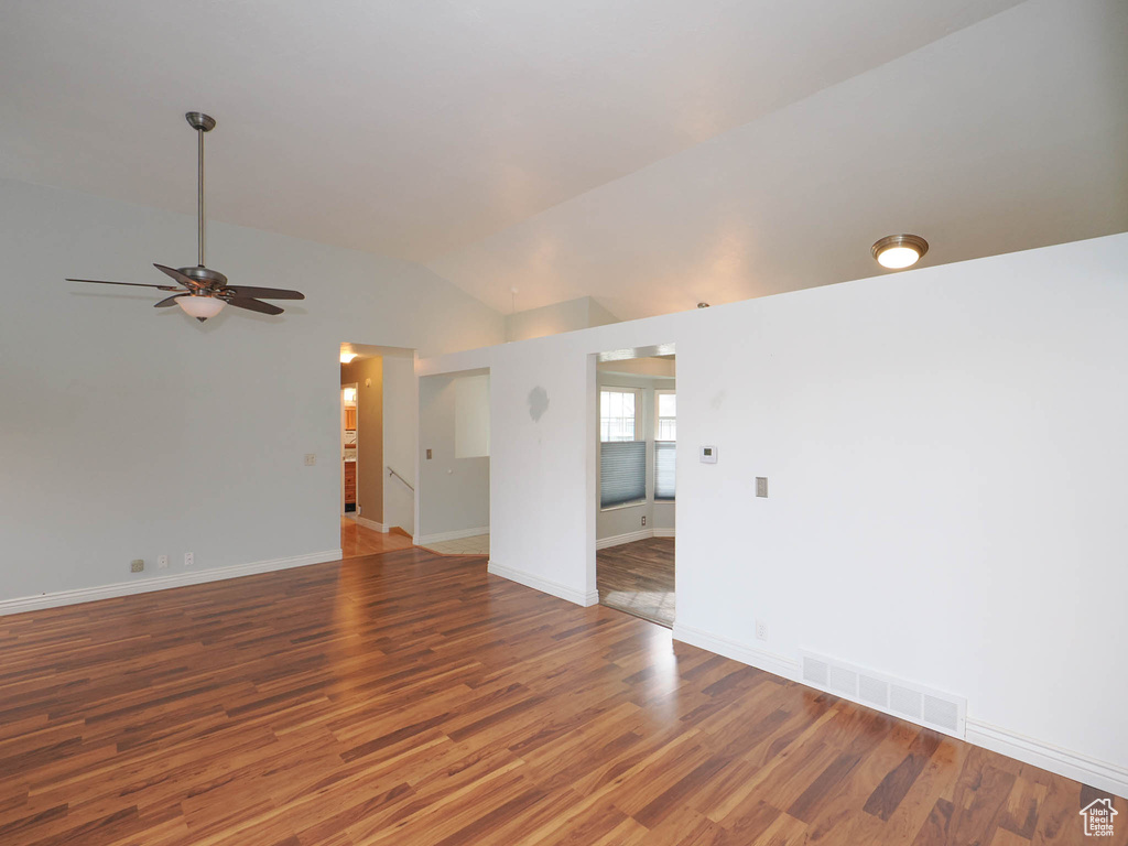 Unfurnished room featuring lofted ceiling, dark hardwood / wood-style floors, and ceiling fan