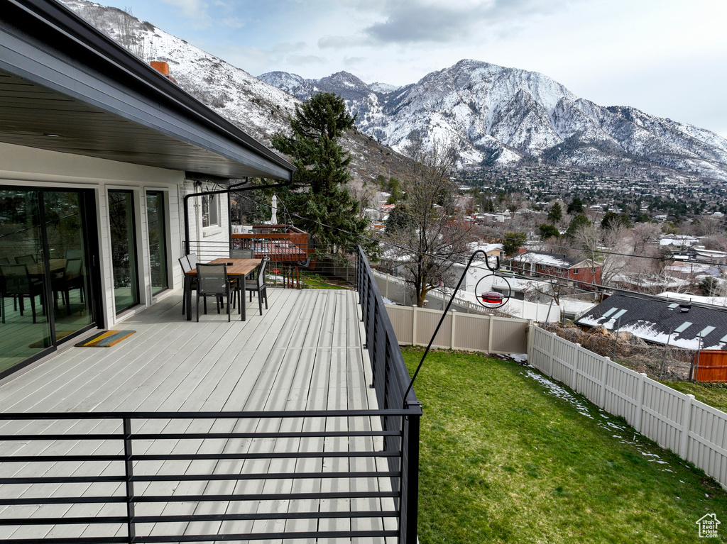 Wooden terrace featuring a lawn and a mountain view