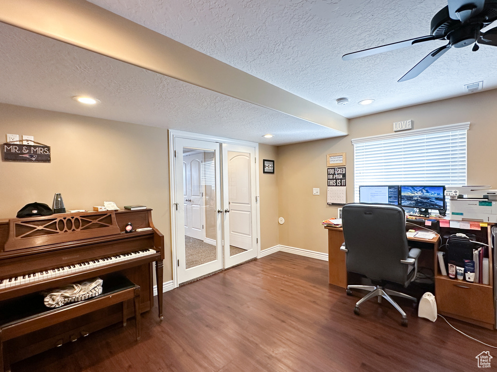 Office with a textured ceiling, ceiling fan, and dark hardwood / wood-style flooring