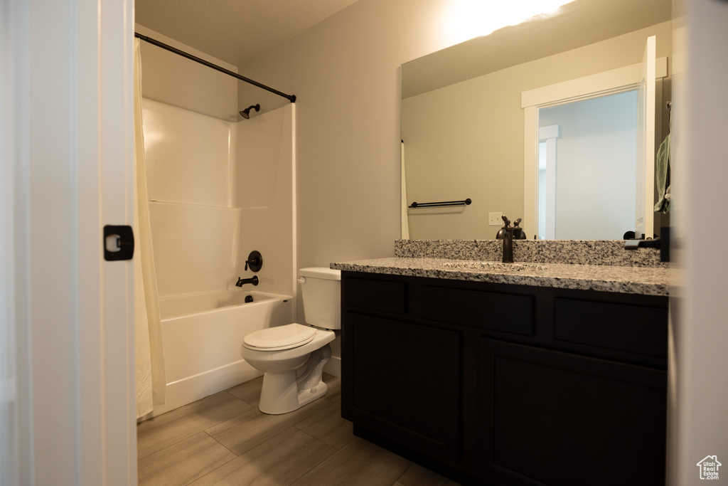 Full bathroom with toilet, vanity with extensive cabinet space, tile floors, and shower / bath combination with curtain