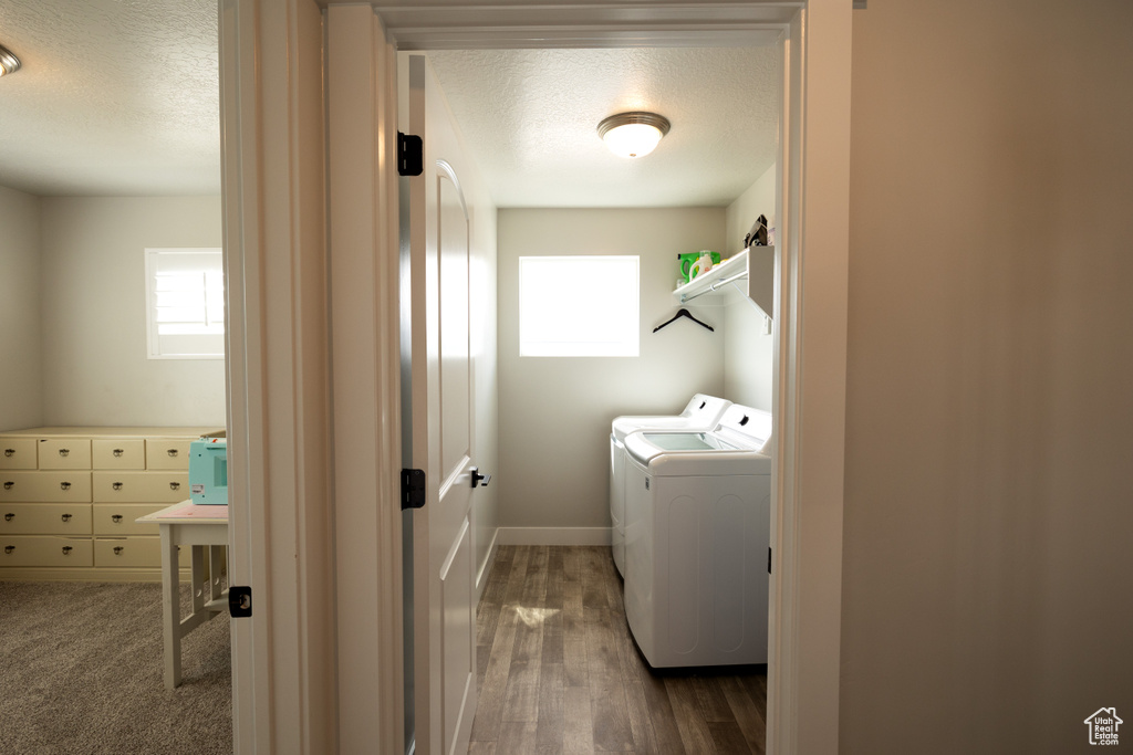 Laundry room featuring washer and clothes dryer, a textured ceiling, and dark hardwood / wood-style floors
