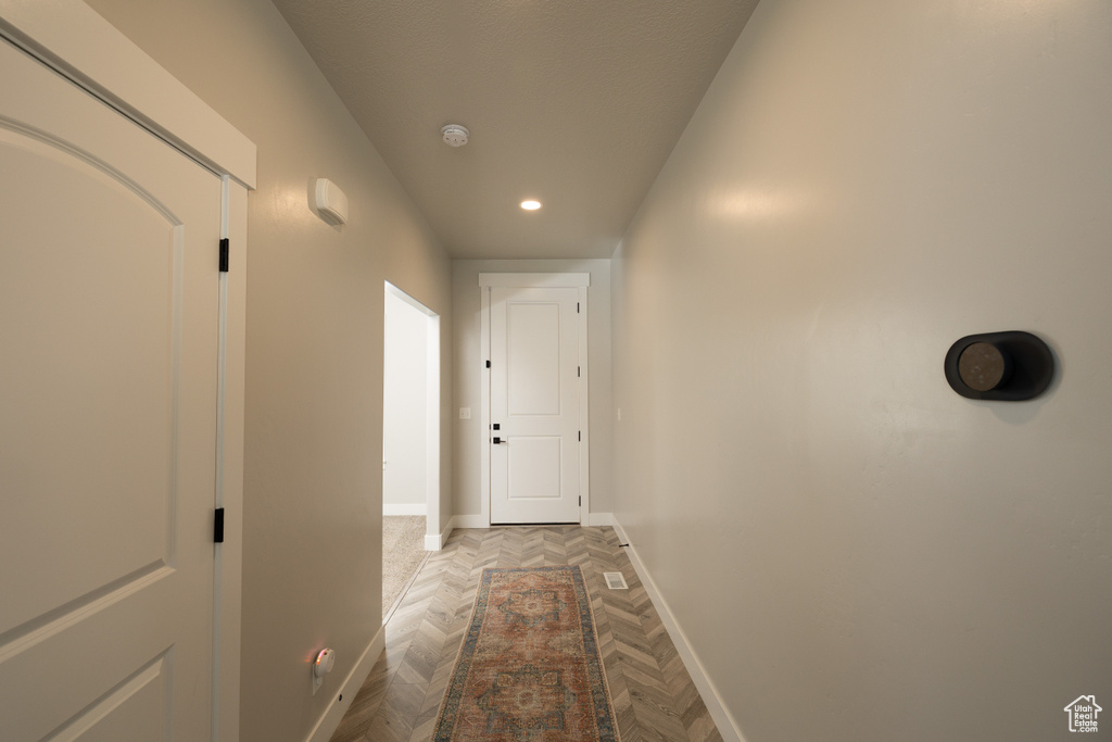 Hallway featuring dark parquet flooring