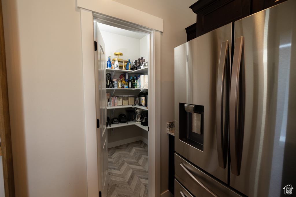 Kitchen featuring dark parquet floors and stainless steel refrigerator with ice dispenser