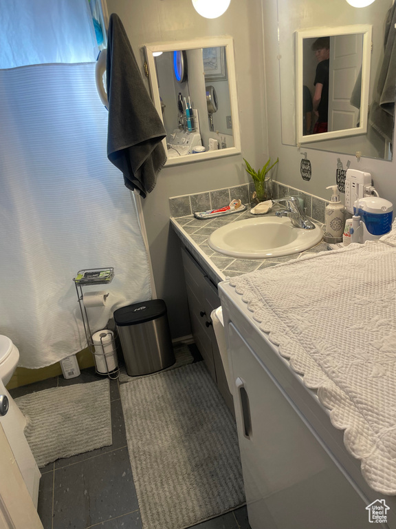 Bathroom with tile floors, oversized vanity, and toilet