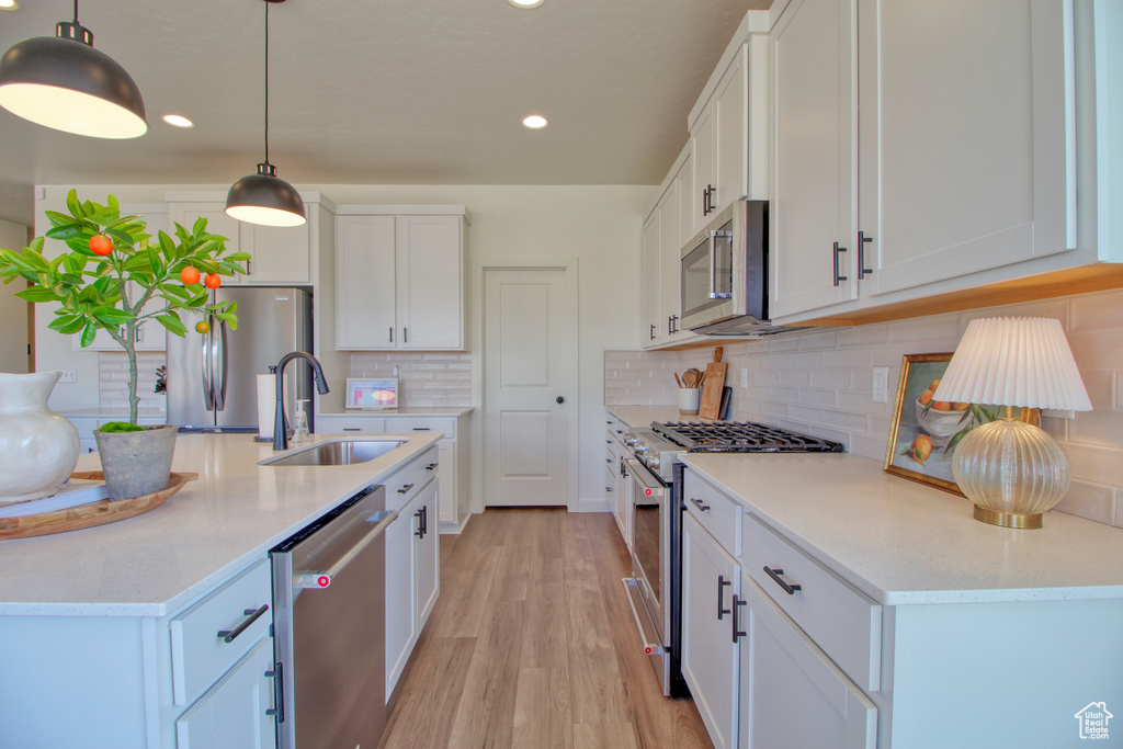 Kitchen with white cabinetry, appliances with stainless steel finishes, and sink