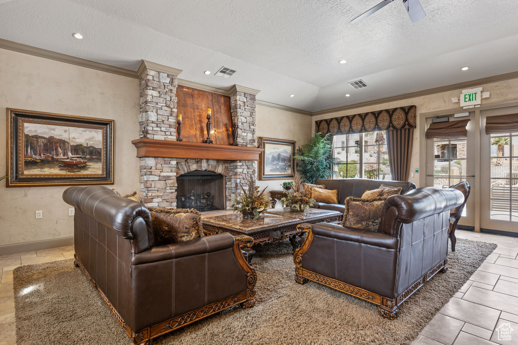 Living room featuring light tile flooring, a stone fireplace, vaulted ceiling, and a textured ceiling