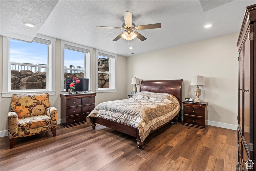 Bedroom featuring a textured ceiling, ceiling fan, and dark hardwood / wood-style floors
