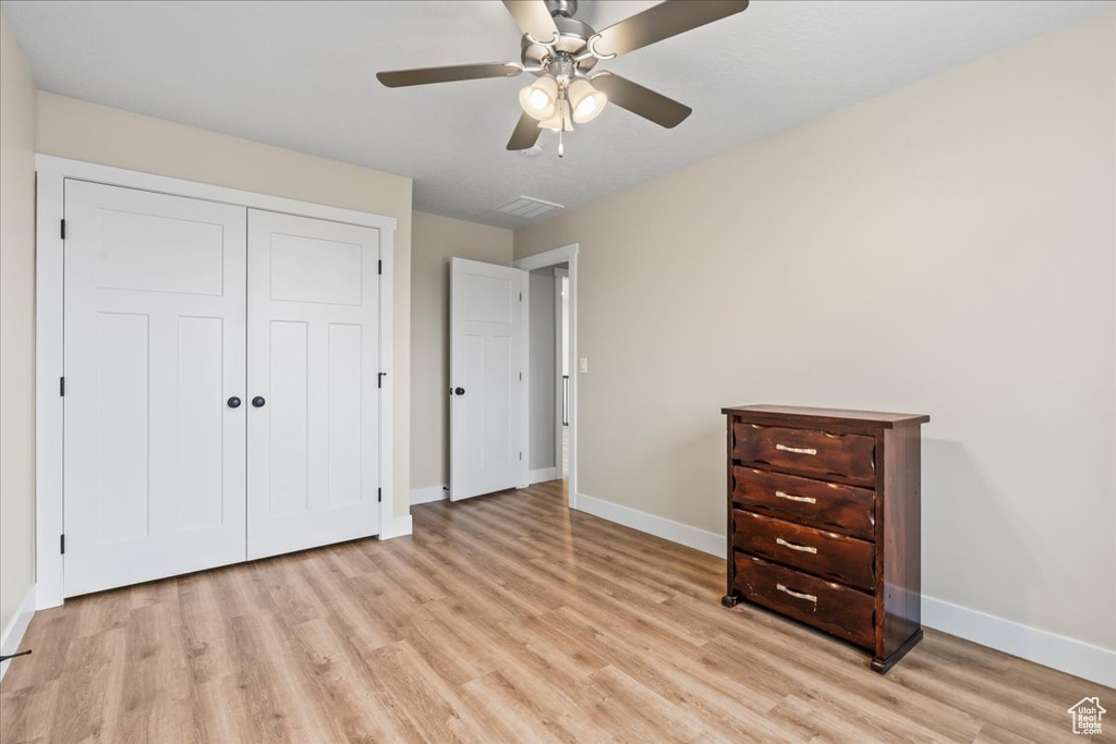 Unfurnished bedroom featuring a closet, ceiling fan, and light hardwood / wood-style flooring
