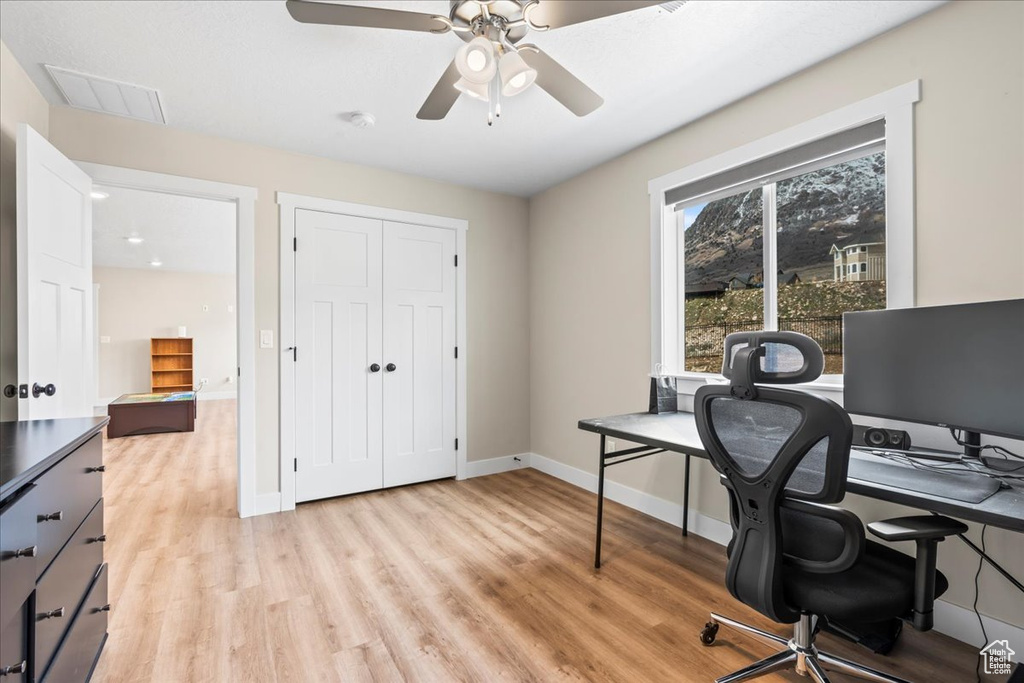 Home office featuring light hardwood / wood-style flooring and ceiling fan
