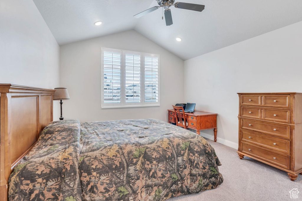 Bedroom featuring light colored carpet, vaulted ceiling, and ceiling fan