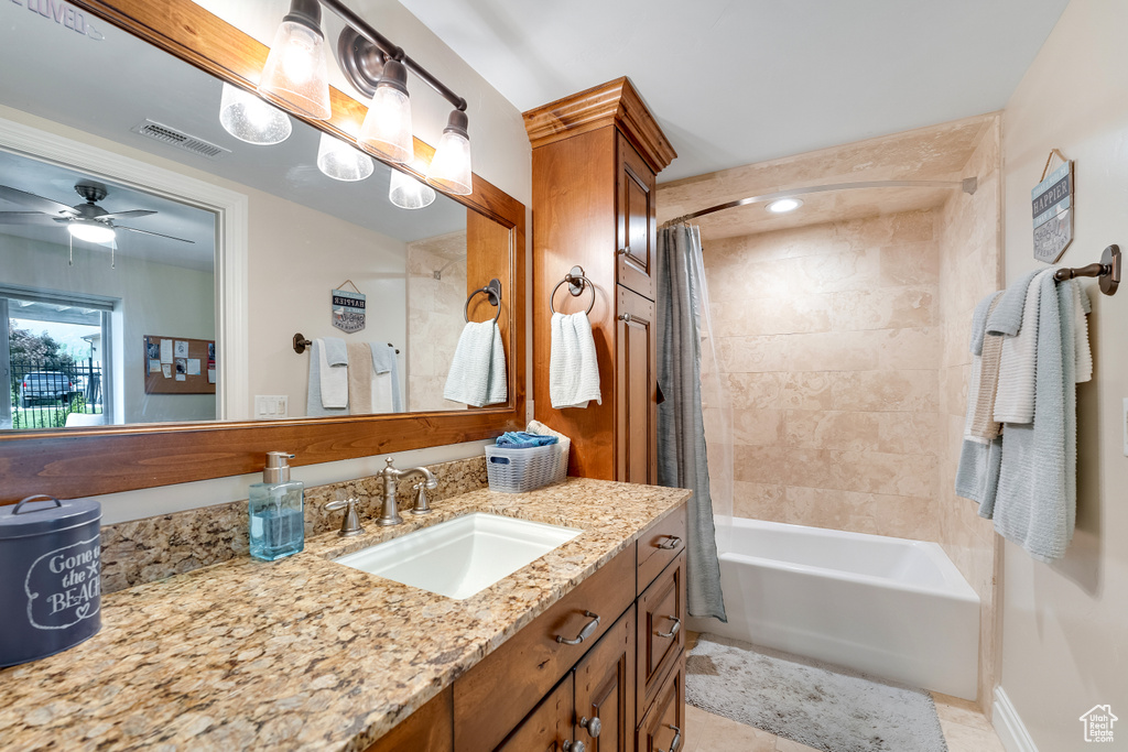 Bathroom featuring shower / bath combo, tile flooring, vanity with extensive cabinet space, and ceiling fan