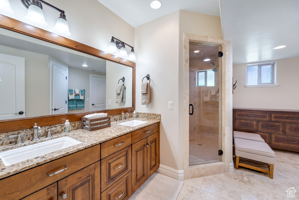 Bathroom featuring oversized vanity, an enclosed shower, double sink, and tile flooring