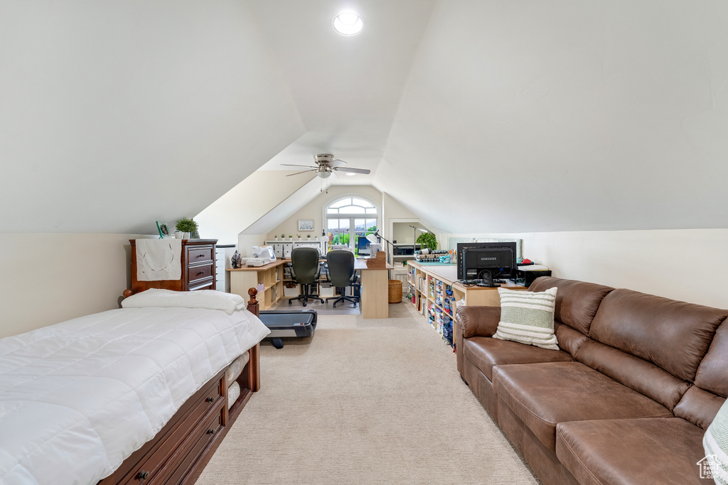 Bedroom with ceiling fan, vaulted ceiling, and light colored carpet