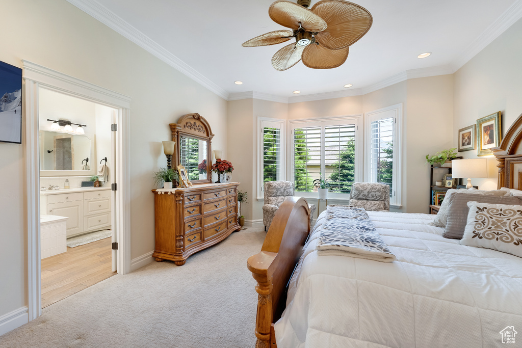 Bedroom featuring crown molding, ensuite bath, light colored carpet, and ceiling fan