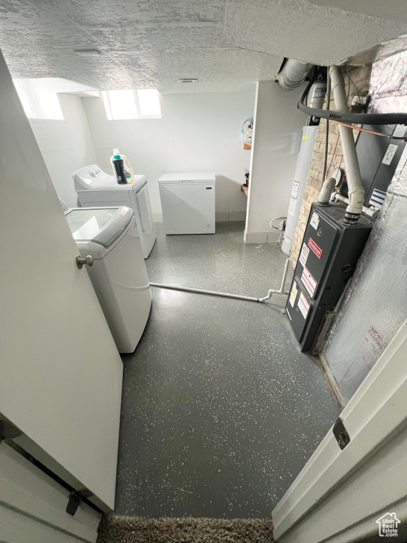 Laundry area with a textured ceiling and independent washer and dryer