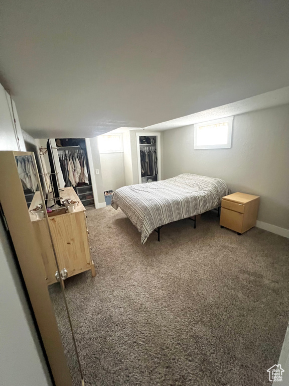 Bedroom with dark carpet and a closet