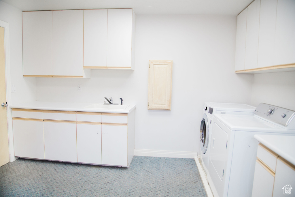 Laundry room with independent washer and dryer, light tile floors, cabinets, and sink